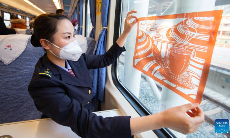 A stewardess decorates the train T8010 at Quanzhou railway station in Quanzhou, southeast China's Fujian Province, Dec. 30, 2022. The 464-km railway linking Xingguo in east China's Jiangxi Province and Quanzhou in southeast China's Fujian Province, started operation on Friday. The designed speed of the line is 160 km/h. Photo: Xinhua