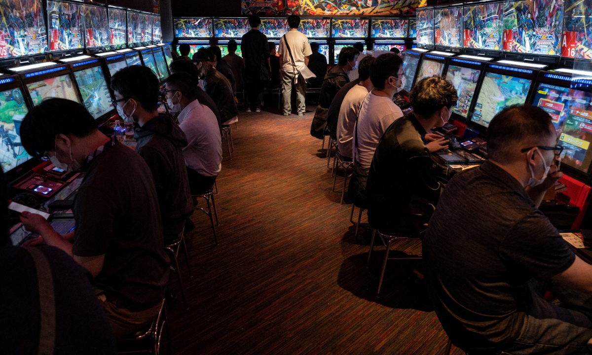 People play video games in the popular electronics shopping area of Akihabara in Tokyo, Japan. File photo: AFP