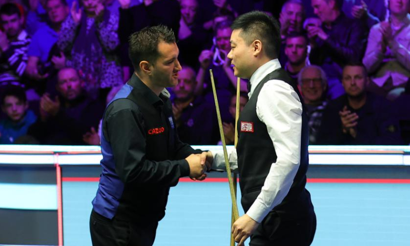 Ding Junhui (R) of China shakes hands with Tom Ford of England after the semifinal match at 2022 UK Snooker Championship in York, Britain, Nov. 19, 2022. (Photo by Zhai Zheng/Xinhua)