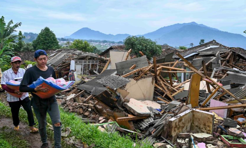 Villagers walk past damaged houses in Cianjur, West Java, Indonesia, Nov. 26, 2022. The death toll of the 5.6-magnitude earthquake hitting Indonesia's West Java province increased to 310, and 24 others were still missing, an official said on Friday. (Xinhua/Zulkarnain)