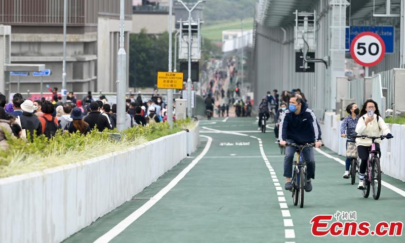 Residents ride bicycles on the Tseung Kwan O Cross Bay Bridge in south China's Hong Kong Special Administrative Region, Dec. 11, 2022. (Photo: China News Service/Li Zhihua)