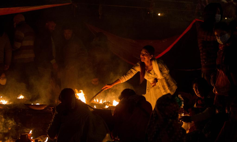 A woman lights an oil lamp during the Bala Chaturdashi Festival at the Pashupatinath Temple in Kathmandu, Nepal, Nov. 21, 2022. (Photo by Sulav Shrestha/Xinhua)