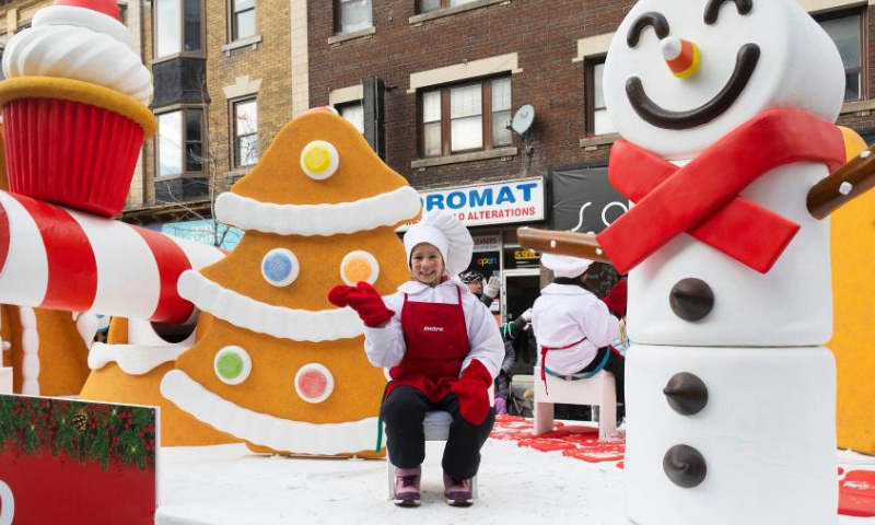 A dressed-up child waves to people on a float during the 2022 Toronto Santa Claus Parade in Toronto, Canada, on Nov. 20, 2022. Featuring themed floats and marching bands, the annual parade returned in-person here on Sunday this year. (Photo by Zou Zheng/Xinhua)