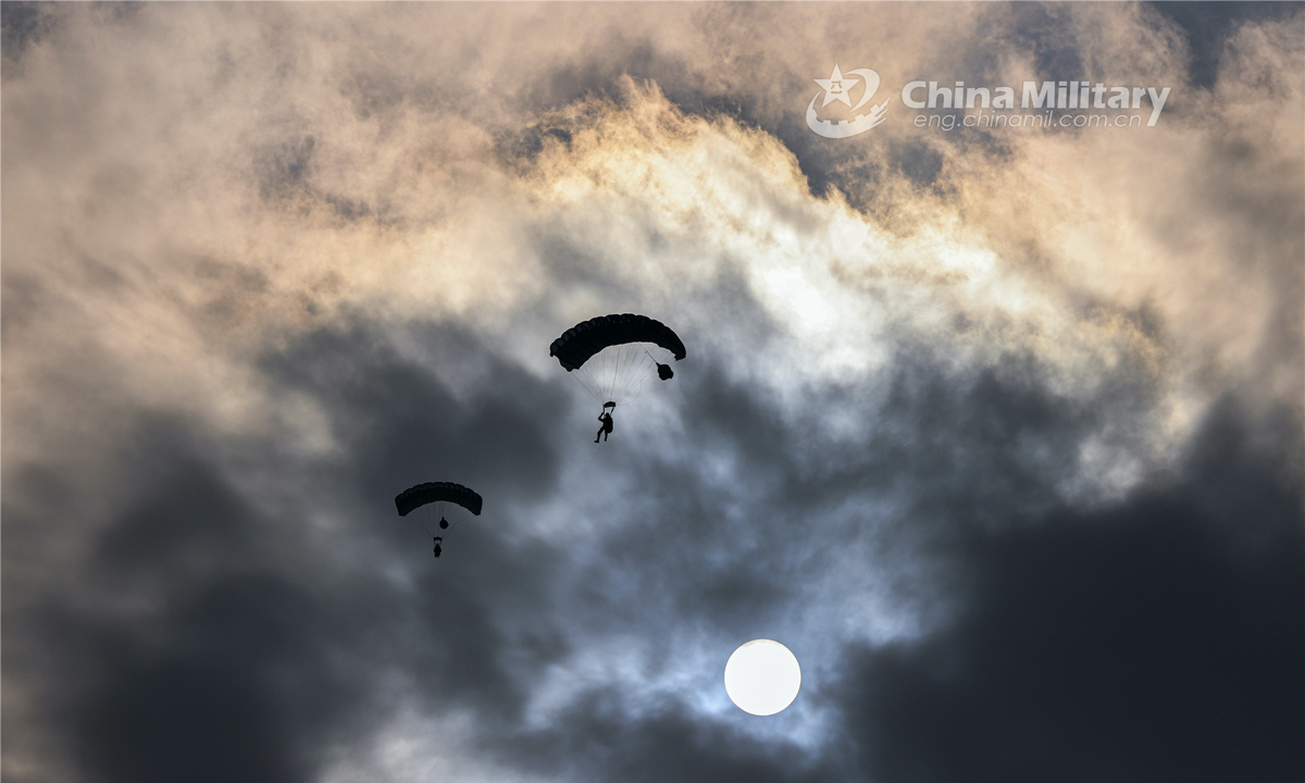 Airmen descend to the drop zone with their parachutes during a parachuting training exercise organized by an airborne brigade of the PLA Air Force on November 25, 2022. (eng.chinamil.com.cn/Photo by Yao Shiquan)