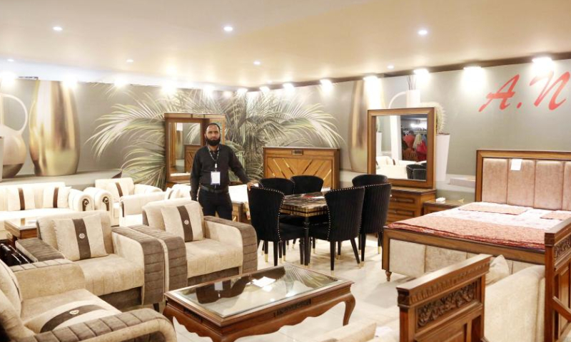 An exhibitor waits for customers during a lifestyle and furniture expo in southern Pakistani port city of Karachi on Dec. 11, 2022. A three-day furniture and living expo ends in Karachi on Sunday, showcasing a vast range of home and office furniture, decorative accessories, massagers and fitness machines, rugs and carpets. (Xinhua/Ahmad Kamal)