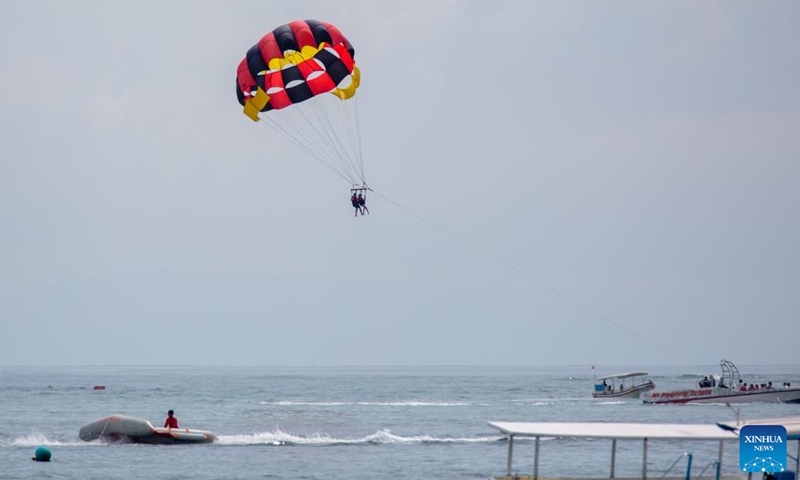 Tourists experience parasailing near Tanjung Benoa beach in Bali, a famous tourist destination of Indonesia, Nov. 12, 2022. (Xinhua/Wang Yiliang)