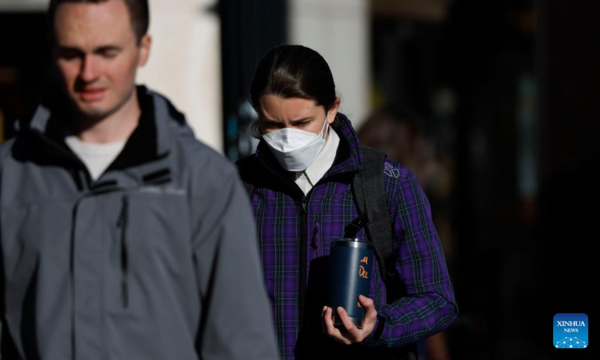 A woman wearing a face mask is seen on a street in Washington, DC, the United States, on Dec 16, 2022. Photo:Xinhua