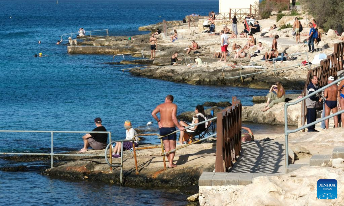People spend time at the seaside of the Mediterranean Sea in Sliema, Malta, on Dec. 16, 2022. The maximum temperature reached 24 degrees Celsius in Malta on Friday, the warmest December day in almost 60 years, according to the country's meteorological office. Photo:Xinhua