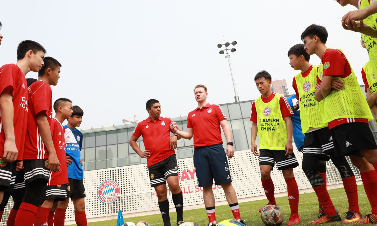 Matthias Brosamer (second left) and FC Bayern legendary striker Giovane Elber (first left) direct young Chinese players in FC Bayern soccer school in Qingdao, East China’s Shandong Province in April 2019. Photo: Courtesy of Brosamer