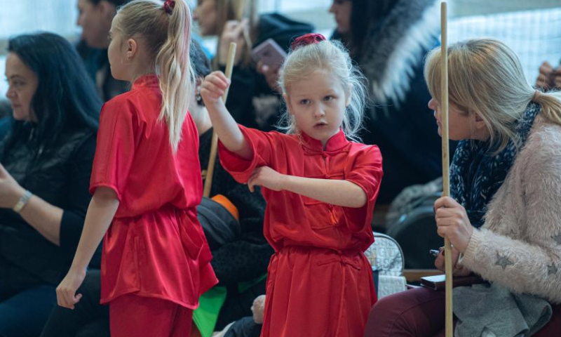 An athlete (2nd R) prepares at the 8th Lithuanian Wushu (Kung Fu) Championship in Vilnius, Lithuania, on Dec. 10, 2022. The 8th Lithuanian Wushu (Kung Fu) Championship kicked off on Dec. 10, attracting nearly 100 competitors from Lithuania, Poland, Estonia, India and other countries to take part in. (Photo by Alfredas Pliadis/Xinhua)