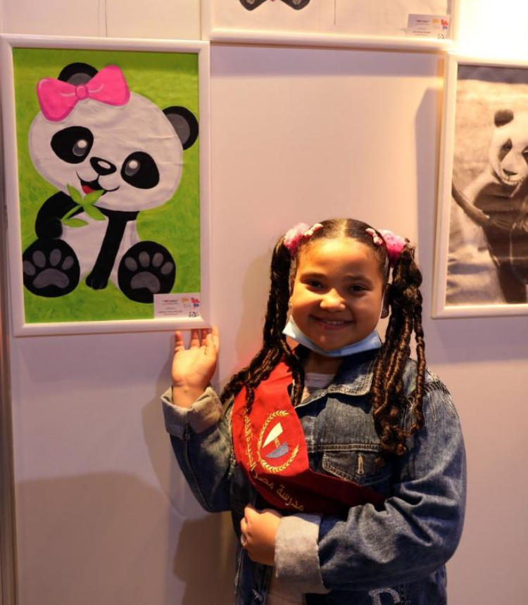 A student poses during the exhibition of works of the 