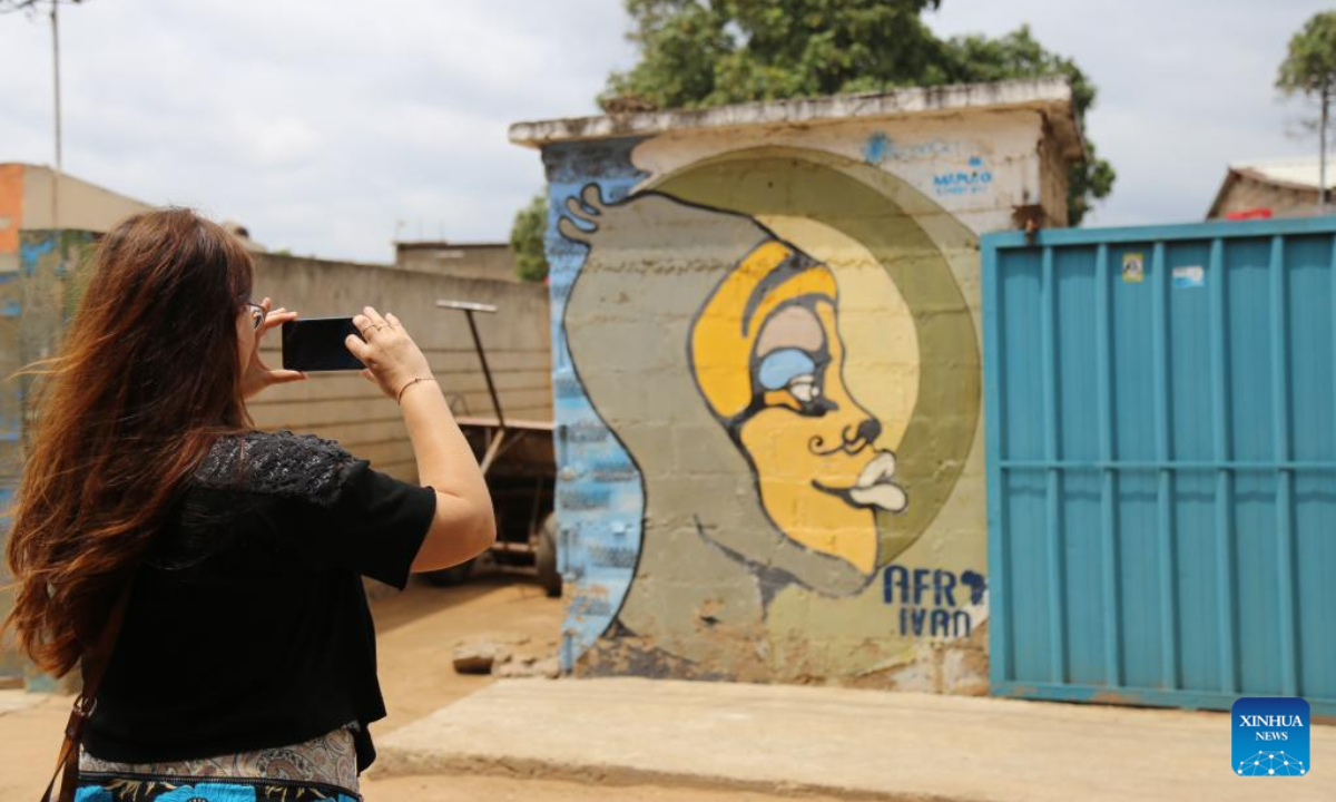 A tourist takes a photo of a painting on the wall in the slum area, Unit Seven of Maputo, Mozambique, Nov 13, 2022. Photo:Xinhua