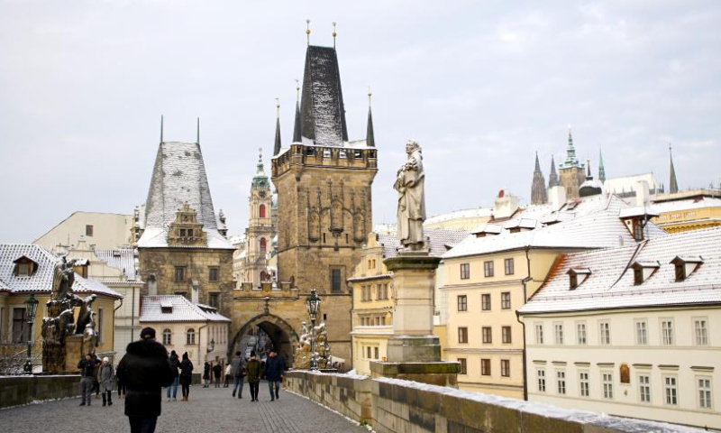 People walk on the Charles Bridge after snow in Prague, the Czech Republic, Nov. 19, 2022. (Photo by Dana Kesnerova/Xinhua)