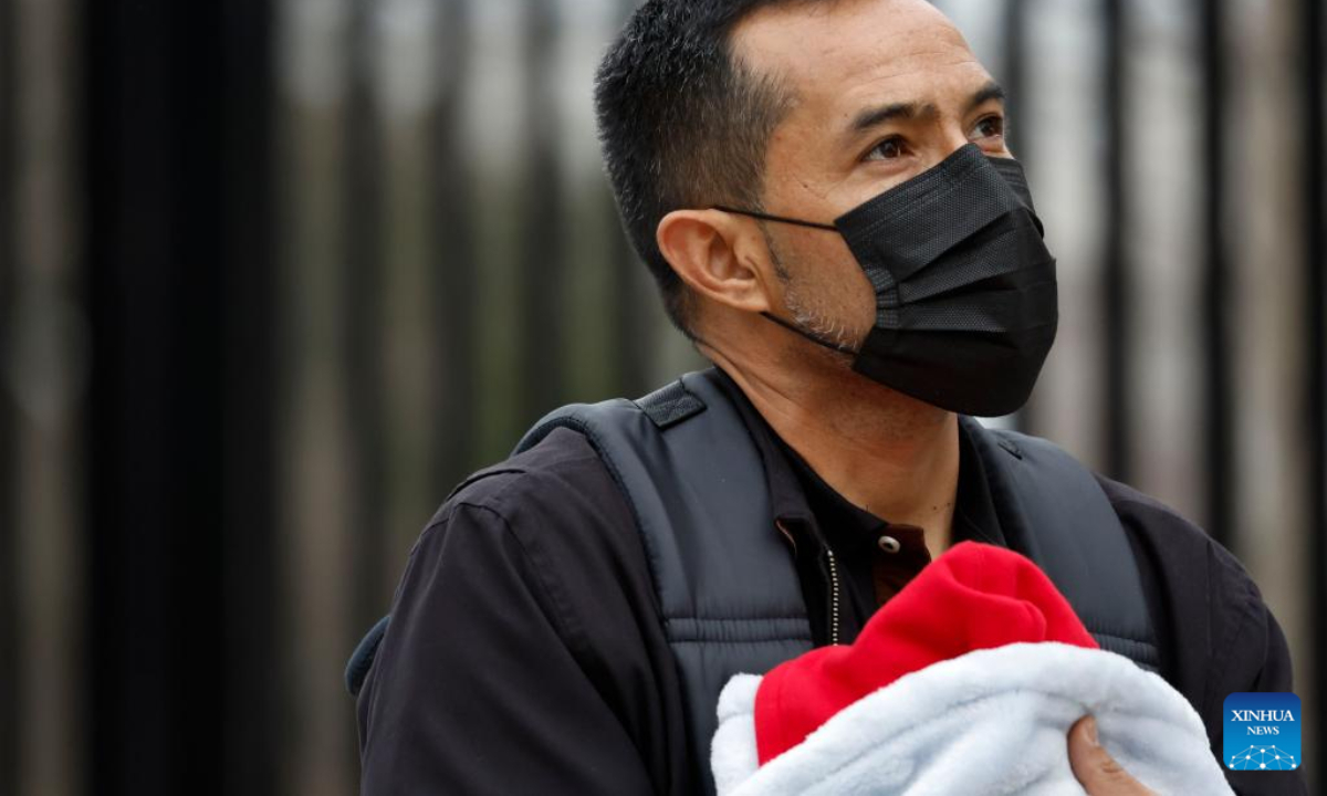 A man wearing a face mask is seen on a street in Washington, DC, the United States, on Dec 16, 2022. Photo:Xinhua