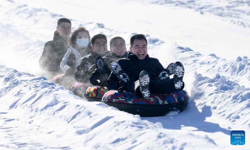 People participate in snow entertainment at a ski resort in Kazak Autonomous County of Mori, northwest China's Xinjiang Uygur Autonomous Region, Dec. 12, 2022. The 2nd snow and ice tourism carnival in Kazak Autonomous County of Mori kicked off on Monday. (Xinhua/Wang Fei)
