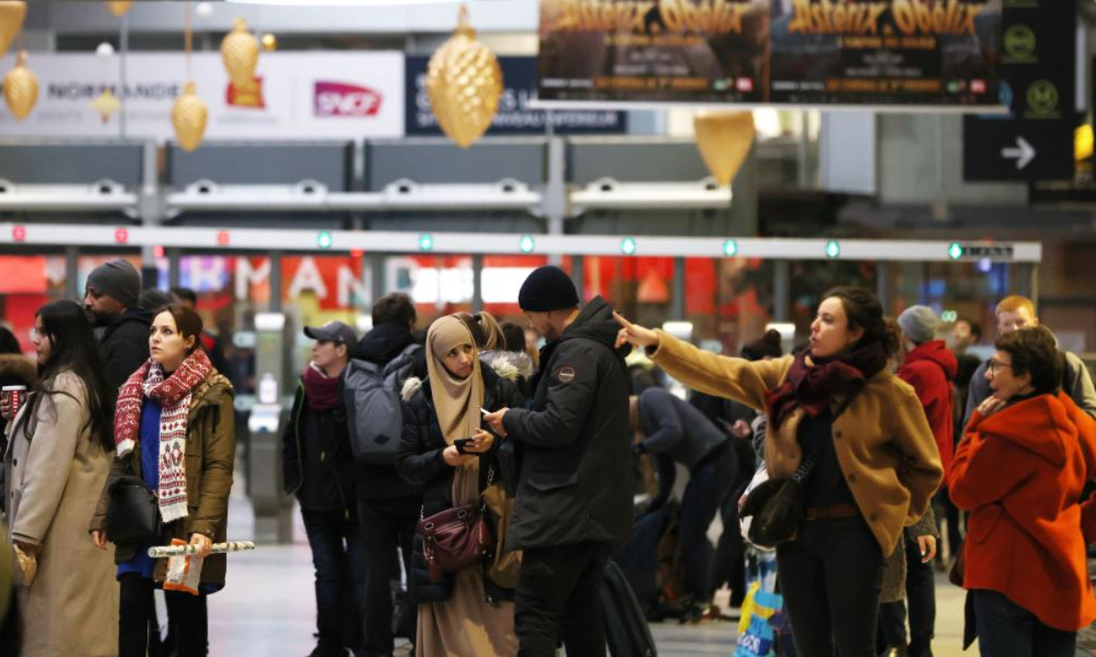 Passengers look at the information panels at Gare Saint Lazare train station in Paris, France, Dec 23, 2022. Photo:Xinhua