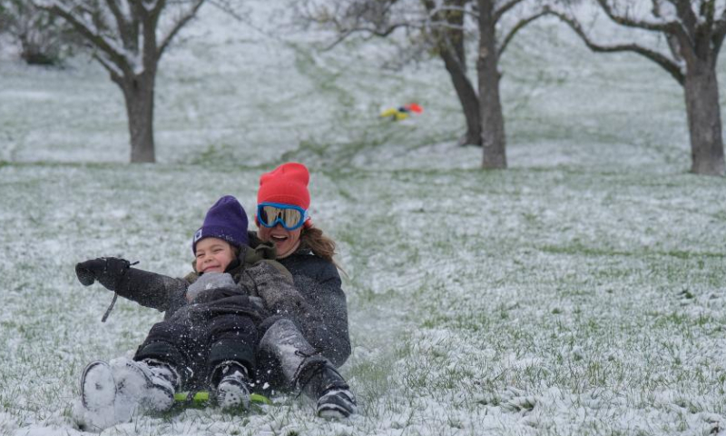 People play with snow at a park in Prague, the Czech Republic, Nov. 19, 2022. (Xinhua/Deng Yaomin)