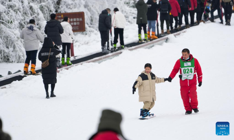 A young tourist practices skiing under the guidance of an instructor at a ski resort in Chongqing, southwest China, Jan. 1, 2023. The three-day New Year holiday witnessed a strong recovery in tourism, catering and retail sales across the country. (Xinhua/Liu Chan)
