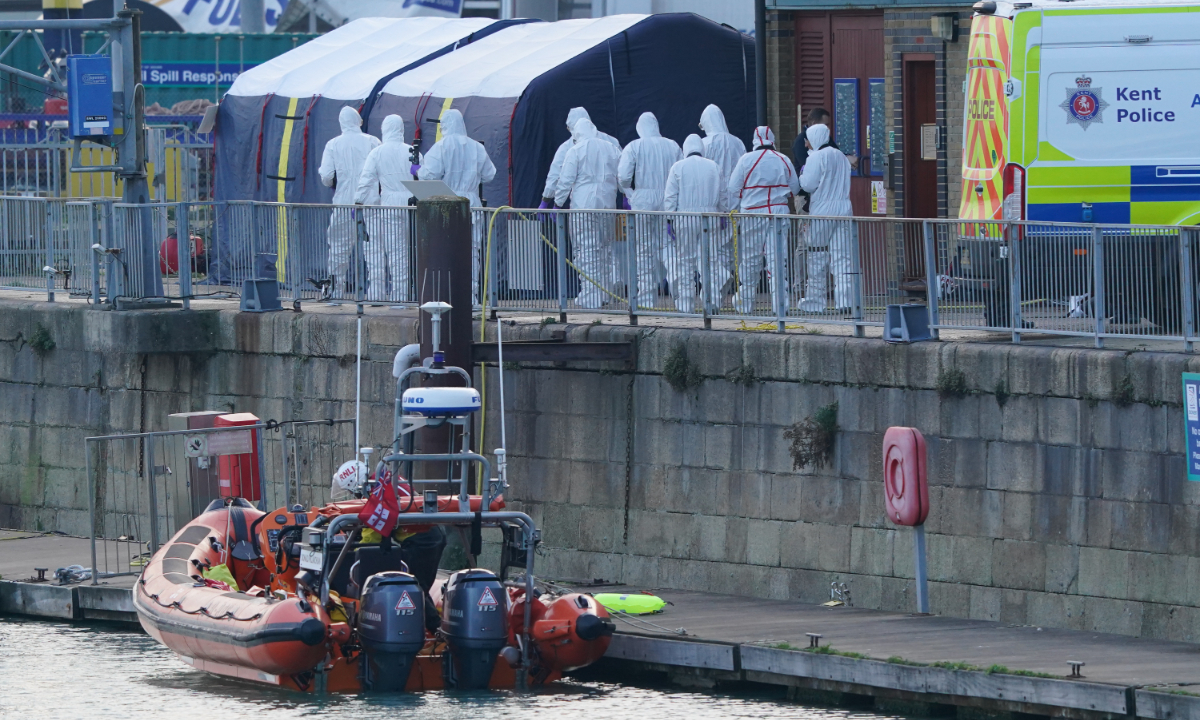 Police Forensic officers head to the forensic tents erected at the RNLI station at the Port of Dover in Kent, the UK on December 14, 2022, after a small boat carrying migrants capsized. Four people have died and 43 people have been rescued. Photo: VCG