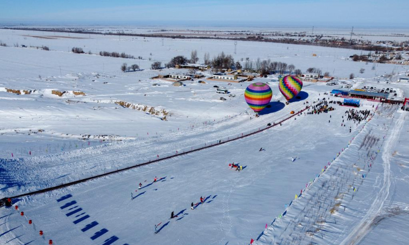 People participate in snow entertainment at a ski resort in Kazak Autonomous County of Mori, northwest China's Xinjiang Uygur Autonomous Region, Dec. 12, 2022. The 2nd snow and ice tourism carnival in Kazak Autonomous County of Mori kicked off on Monday. (Xinhua/Wang Fei)