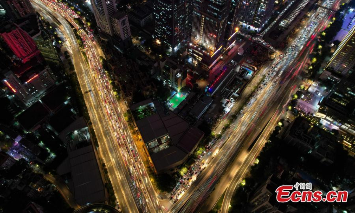 无人机照片显示了 2022 年 12 月 1 日在中国南方广东省广州市一座带车灯的立交桥的空中夜景。照片：中新社