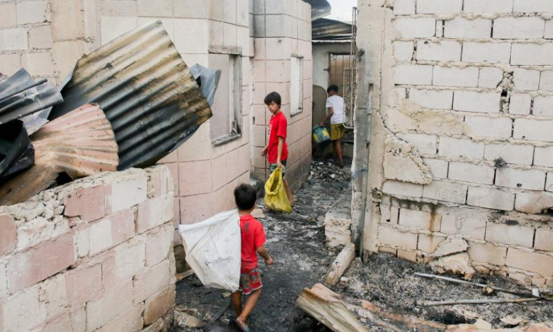 Children search for reusable materials from their charred homes after a fire at a slum area in Navotas City, the Philippines, Nov. 15, 2022. Photo: Xinhua
