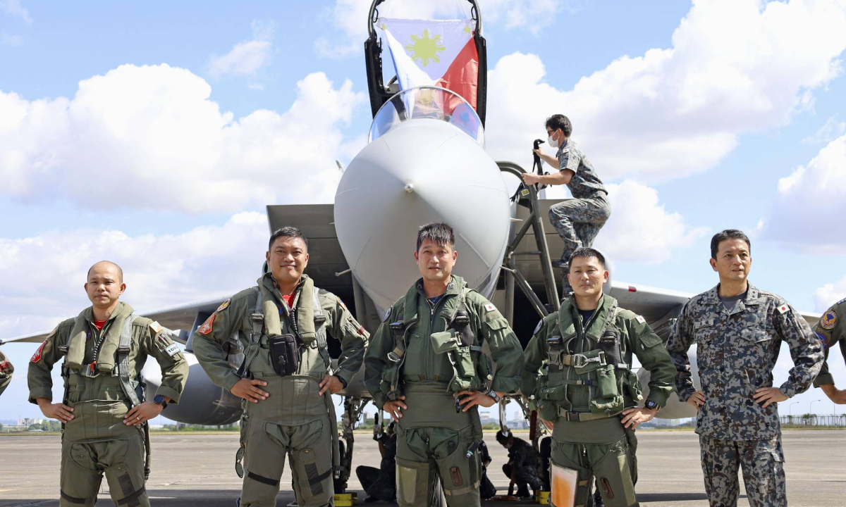 Philippine Air Force (left and second from left) and Japanese Air Self-Defense Force personnel mark the historic arrival of two ASDF F-15 fighter jets with a photo at Clark Air Base in Mabalacat, north of Manila, on Tuesday. Photo: KYODO