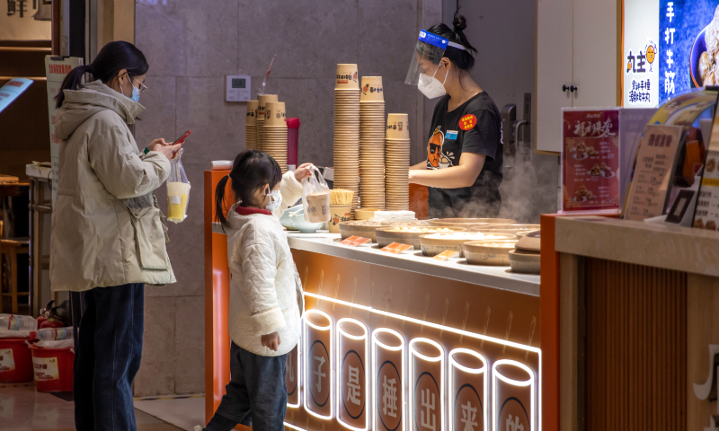 People buy food at a takeaway counter in Zhengzhou, Central China's Henan Province on November 30, 2022. On the same day, the main urban area of Zhengzhou optimized epidemic prevention and control measures and resumed business activities in an orderly manner. Supermarkets, cinemas and subways reopened. Photo: VCG