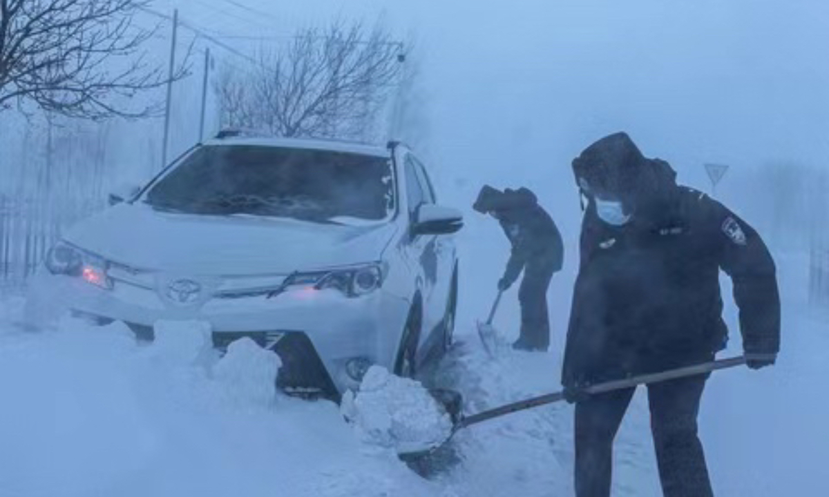 Traffic police assisting vehicles stuck in the snow to get out of trouble. The extreme weather in Altay’s winter pastures led to impassable roads, frostbite of livestock, and people being trapped, as the temperatures plummeted to more than minus 48.6 C. Photo: Caixin News