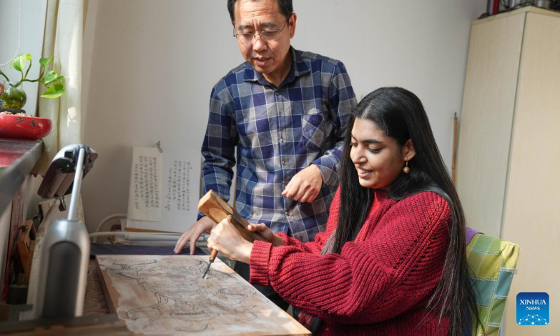 Gurmehar Singh learns how to create Yangliuqing woodblock prints under the instruction of artist Liu Jie in north China's Tianjin, Nov. 17, 2022.