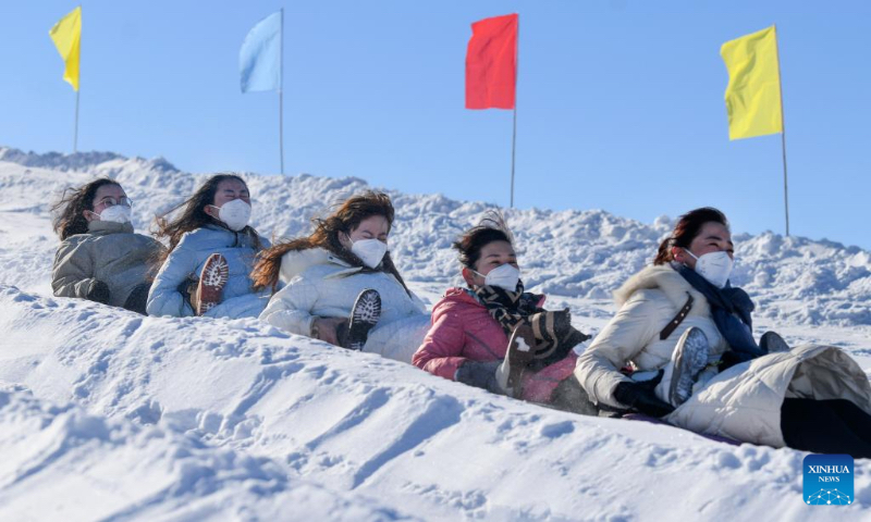 People participate in snow entertainment at a ski resort in Kazak Autonomous County of Mori, northwest China's Xinjiang Uygur Autonomous Region, Dec. 12, 2022. The 2nd snow and ice tourism carnival in Kazak Autonomous County of Mori kicked off on Monday. (Xinhua/Wang Fei)