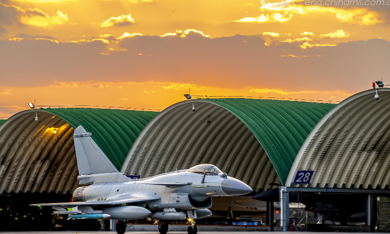Fighter jets attached to an aviation brigade of the air force under the PLA Southern Theater Command taxi out of the hangers successively in sunset prior to a round-the-clock flight training mission on November 8, 2022. (eng.chinamil.com.cn/Photo by Wang Guoyun)