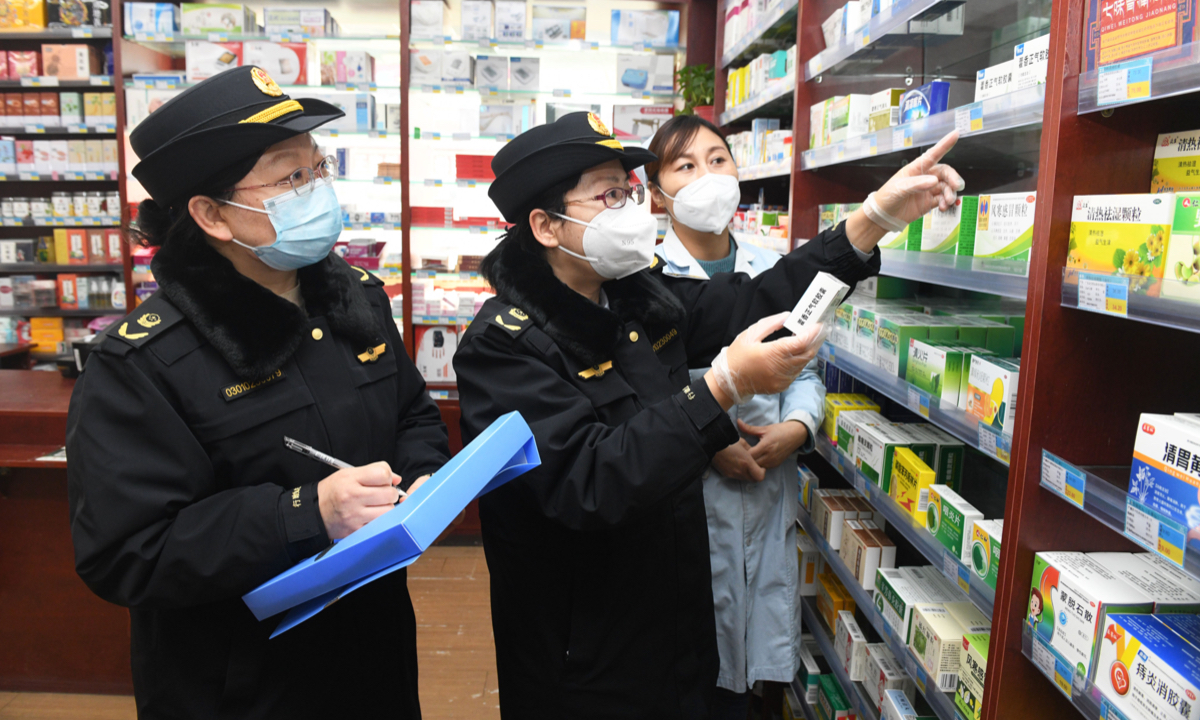 Officials of the local market regulator inspect medicine supplies at a supermarket in Shijiazhuang, North China's Hebei Province on December 15, 2022. As demand surges for anti-epidemic products after the optimization of China’s COVID-19 response, authorities are striving to crack down on price hikes and hoarding to stabilize inventory and prices. Photo: VCG 