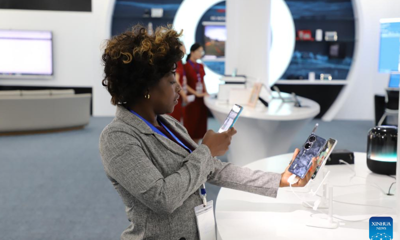A visitor takes photos of a mobile phone displayed at the inauguration ceremony of Huawei Angola Tech Park, in Luanda, Angola on Nov. 14, 2022. Chinese tech giant Huawei has inaugurated a tech park in Angola that's expected to help train more local talents in the information and communication technology (ICT) sector and speed up digitalization in the southern African country. Photo: Xinhua