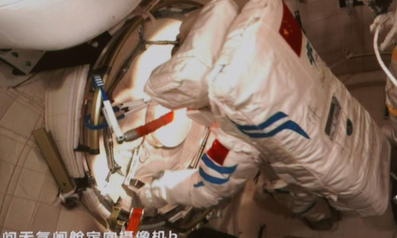 This screen image captured at Beijing Aerospace Control Center on Nov. 17, 2022 shows China's Shenzhou-14 taikonaut Chen Dong (L) closing the hatch of space station lab module Wentian's airlock cabin after finishing extravehicular activities. The Shenzhou-14 crew on board the orbiting Chinese Tiangong space station completed their third spacewalk at 4:50 p.m. (Beijing Time) on Thursday, according to the China Manned Space Agency. Photo: Xinhua