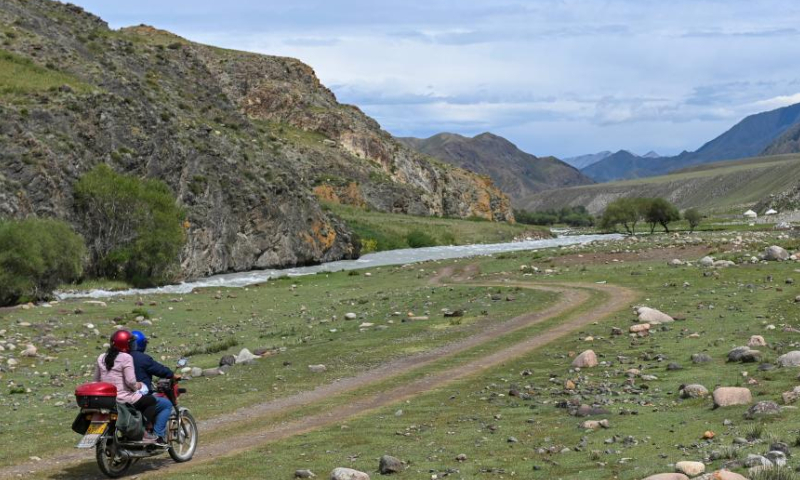 Shan Zhizheng and his wife Yuan Qin return from a cultural relic site patrol on motorcycle in Wenquan County in the Mongolian Autonomous Prefecture of Bortala, northwest China's Xinjiang Uygur Autonomous Region, July 30, 2022. (Xinhua/Hao Jianwei)