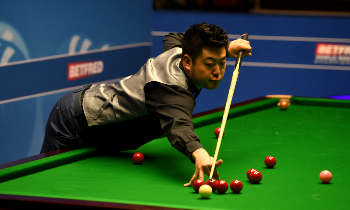 Liang Wenbo plays a shot against Stuart Carrington during their first round match of the World Snooker Championship at Crucible Theatre on April 18, 2017 in Sheffield, England. Photo: VCG