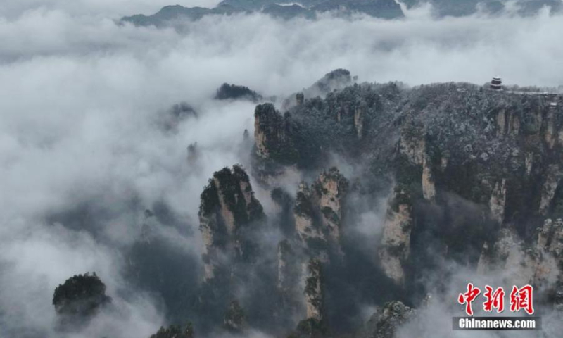 2023 年 1 月 1 日，中国中部湖南省张家界天子山风景区，雾霭覆盖的阿凡达山峰隐藏在云海中。（照片：中新社/张洪涛）
