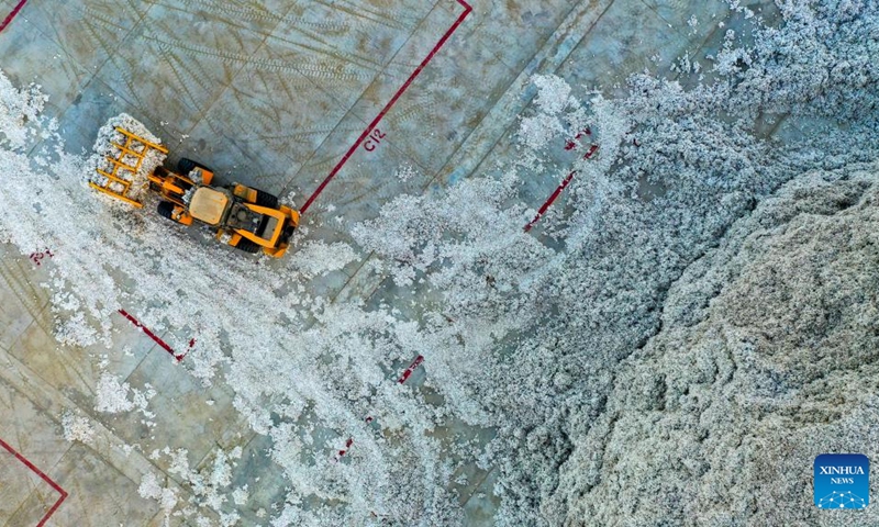 This aerial photo taken on Nov. 11, 2022 shows a vehicle working at a cotton company in Xayar County, northwest China's Xinjiang Uygur Autonomous Region. The cotton harvest is drawing to an end in Xayar County, a premium-quality cotton production base of China. As of Friday, 1.706 million mu (about 113,733 hectares) of cotton has been harvested here. (Photo by Liu Yuzhu/Xinhua)