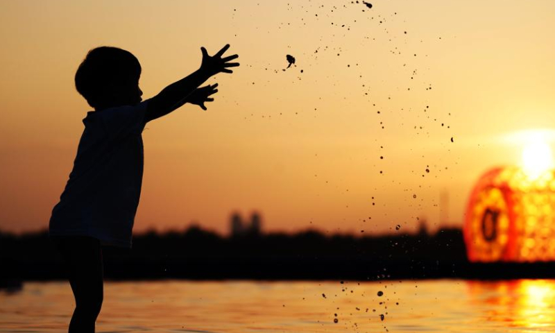 This photo taken on July 30, 2019 shows a child playing along the Songhua River in Harbin, northeast China's Heilongjiang Province. Photo: Xinhua
