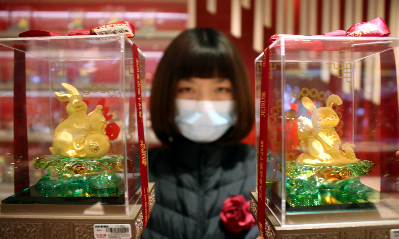 A salesperson shows ornaments in the form of gold rabbits to customers at a gold store in Suzhou, East China's Jiangsu Province, on December 11, 2022. The year 2023 marks the Year of the Rabbit in the Chinese lunar calendar, starting from January 22, 2023. Photo: VCG