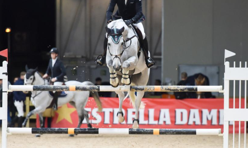 A rider rides a horse during the IFEMA Madrid Horse Week in Madrid, Spain, Nov. 25, 2022. (Photo by Gustavo Valiente/Xinhua)