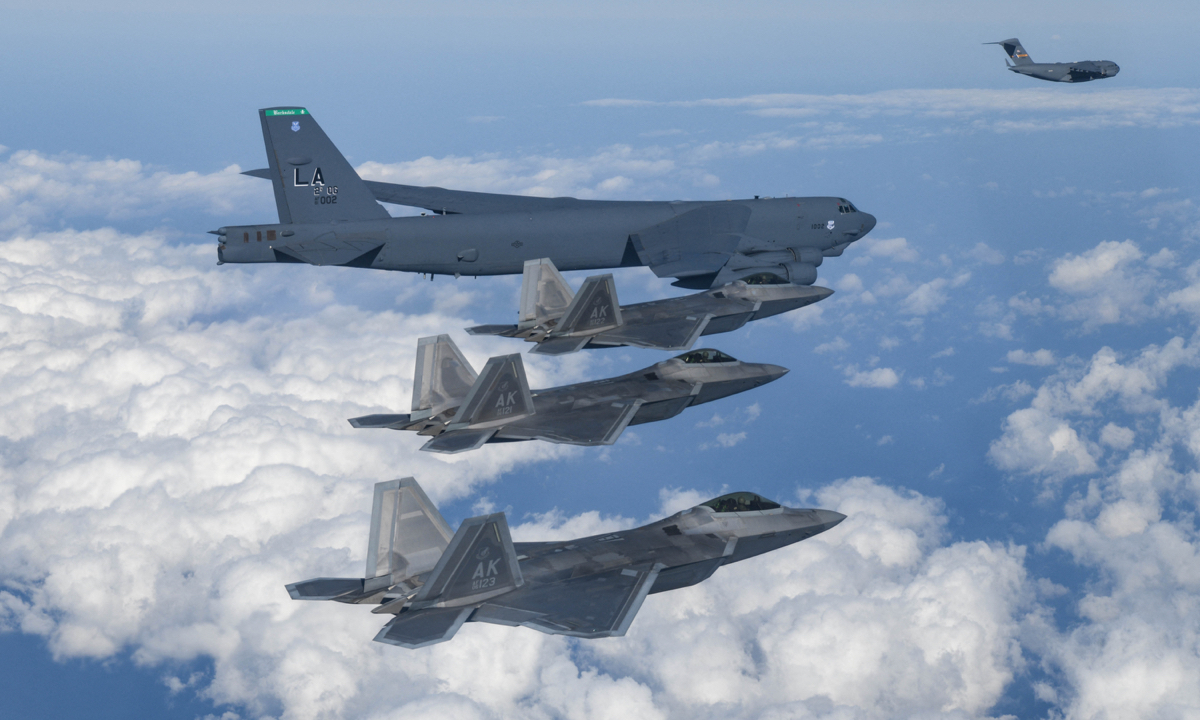This handout photo taken on December 20, 2022 and provided by South Korean Defence Ministry in Seoul shows a US Air Force B-52H strategic bomber (top center), a US Air Force C-17 cargo aircraft (top right) and three US Air Force F-22 fighter jets flying over South Korea during a joint air drill. Photo: AFP