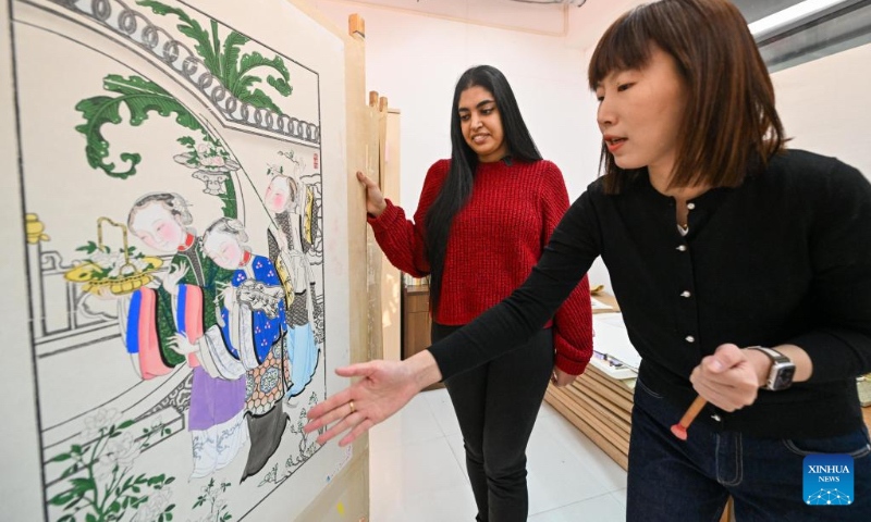 Gurmehar Singh learns from artist Wang Yan (R) about how to create Yangliuqing woodblock prints in north China's Tianjin, Nov. 17, 2022.