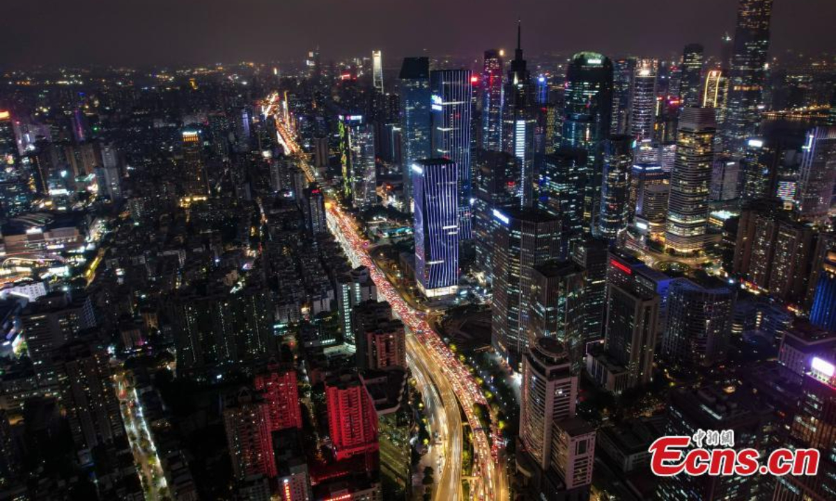 无人机照片显示了 2022 年 12 月 1 日在中国南方广东省广州市一座带车灯的立交桥的空中夜景。照片：中新社
