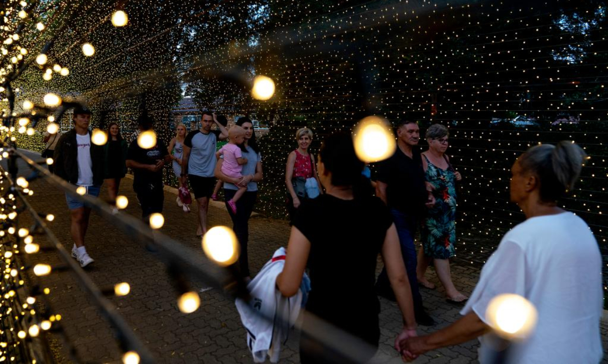 People walk through a light tunnel at a light fair in Potchefstroom, South Africa, Dec 22, 2022. Photo:Xinhua