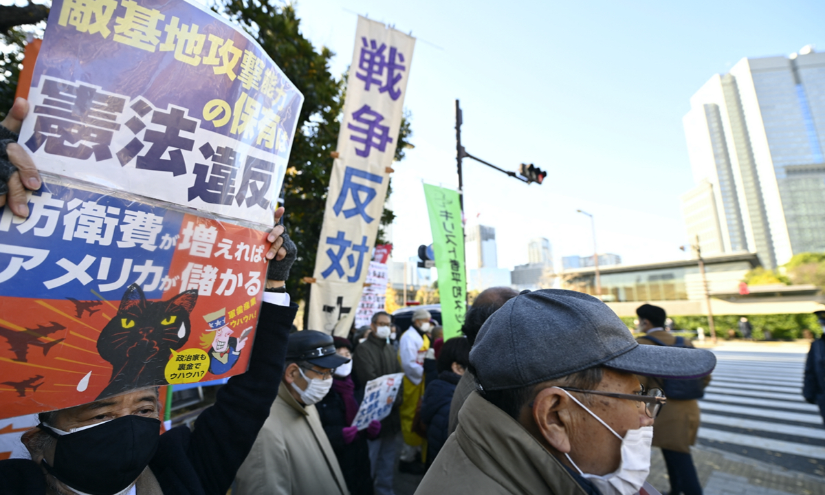 People gather outside Japanese Prime Minister Fumio Kishida’s office holding placards denouncing the violation of Article 9 of the Japanese Constitution in Tokyo on December 16, 2022. They also oppose the increase in the military spending budget. Japan approved its biggest military buildup since World War II on December 16. Photo: AFP