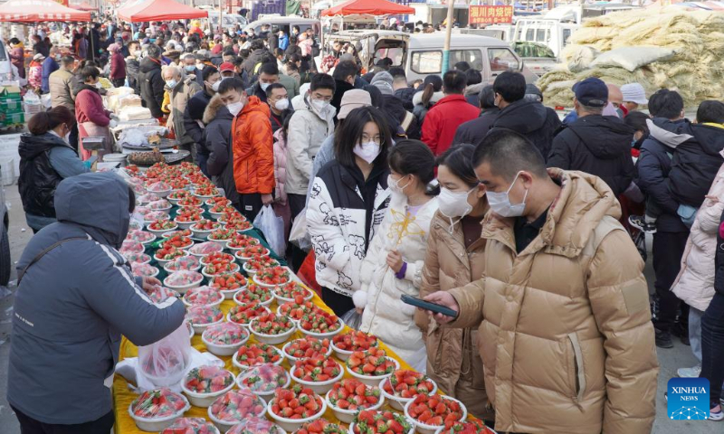 People buy strawberry in a market in Jinan, east China's Shandong Province, Jan. 2, 2023. The three-day New Year holiday witnessed a strong recovery in tourism, catering and retail sales across the country. (Xinhua/Xu Suhui)