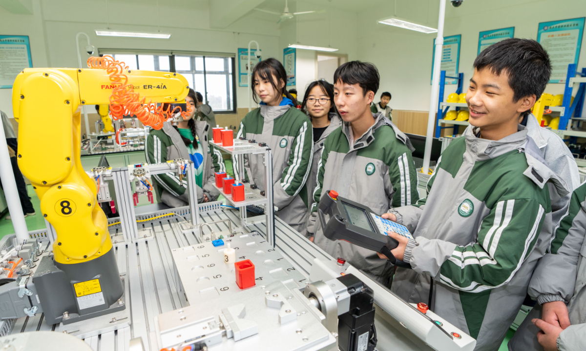 Students from Southwest China’s Sichuan Province learn how to operate robotic arms at a vocational school in Rui’an, East China’s Zhejiang Province on December 6, 2022. China has established the world’s largest vocational education system with 11,200 schools. Photo: cnsphoto