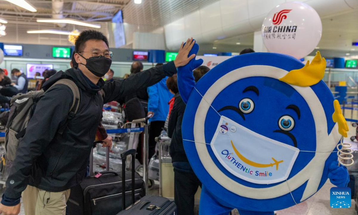 A passenger poses for a photo with an airport mascot at Athens International Airport in Greece, on Dec 22, 2022. Air China launched a new direct flight between China's Shanghai and Greece's Athens on Thursday at Athens International Airport (AIA), the first direct flight between the two cities. Photo:Xinhua